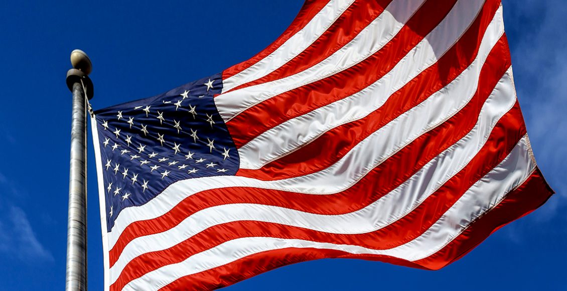 Low Angle View Of American Flag Waving Against Sky
