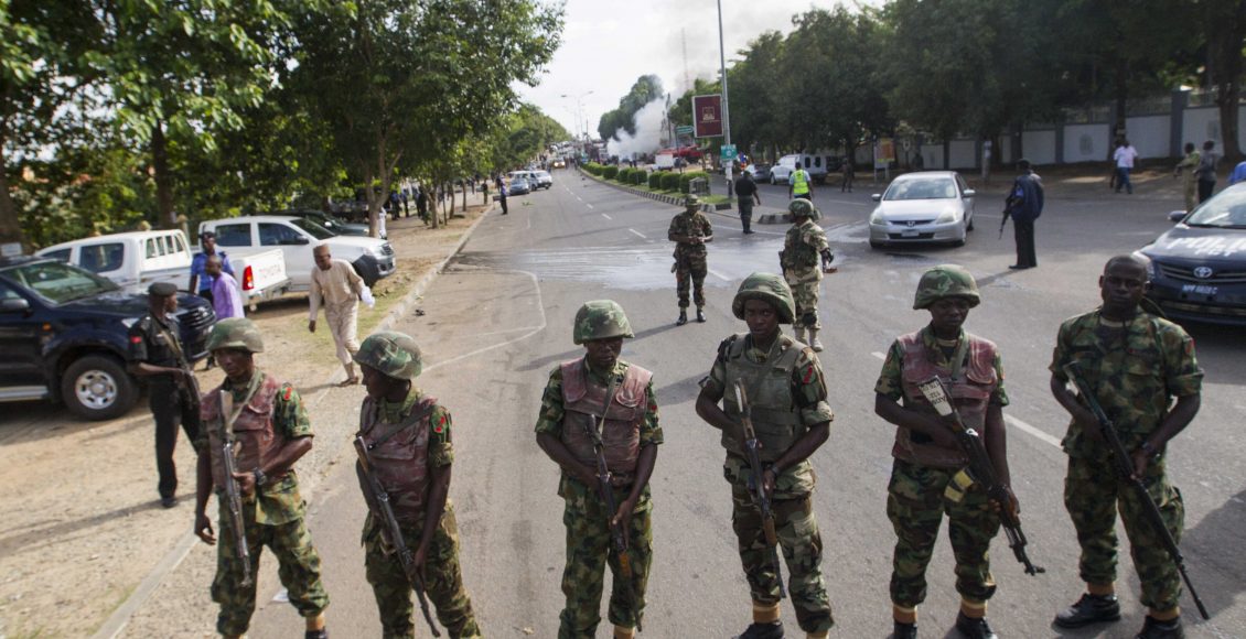 Soldiers cordon off a road leading to the scene of a blast at a business district in Abuja