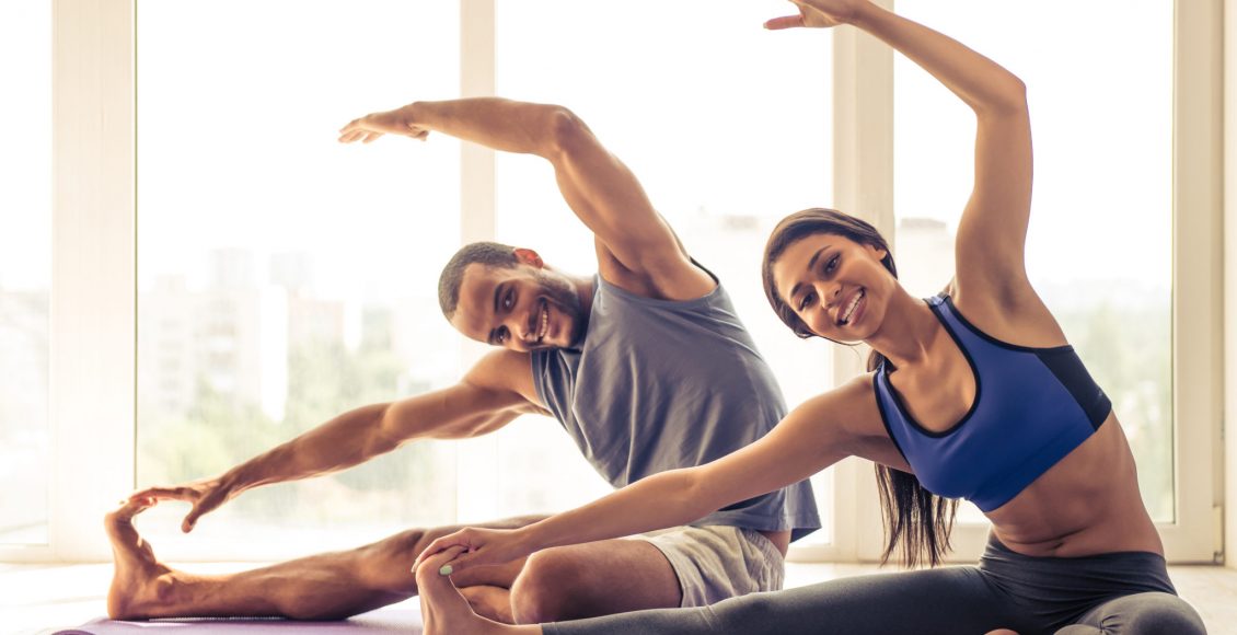 An-African-American-couple-stretching-on-a-yoga-mat-Photo-The-Science-of-Pscyotherapy